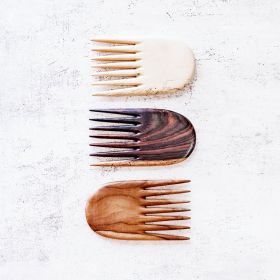 The jambu hair comb in teak, tamarind and rosewood close up view on a table