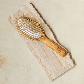 A close up side view of the olive hairbrush with  extra long wooden pins.  