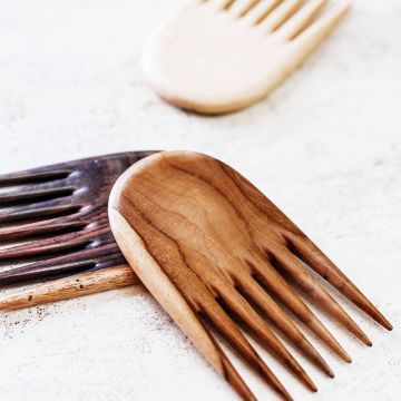The jambu hair comb in teak, tamarind and rosewood close up view on a table